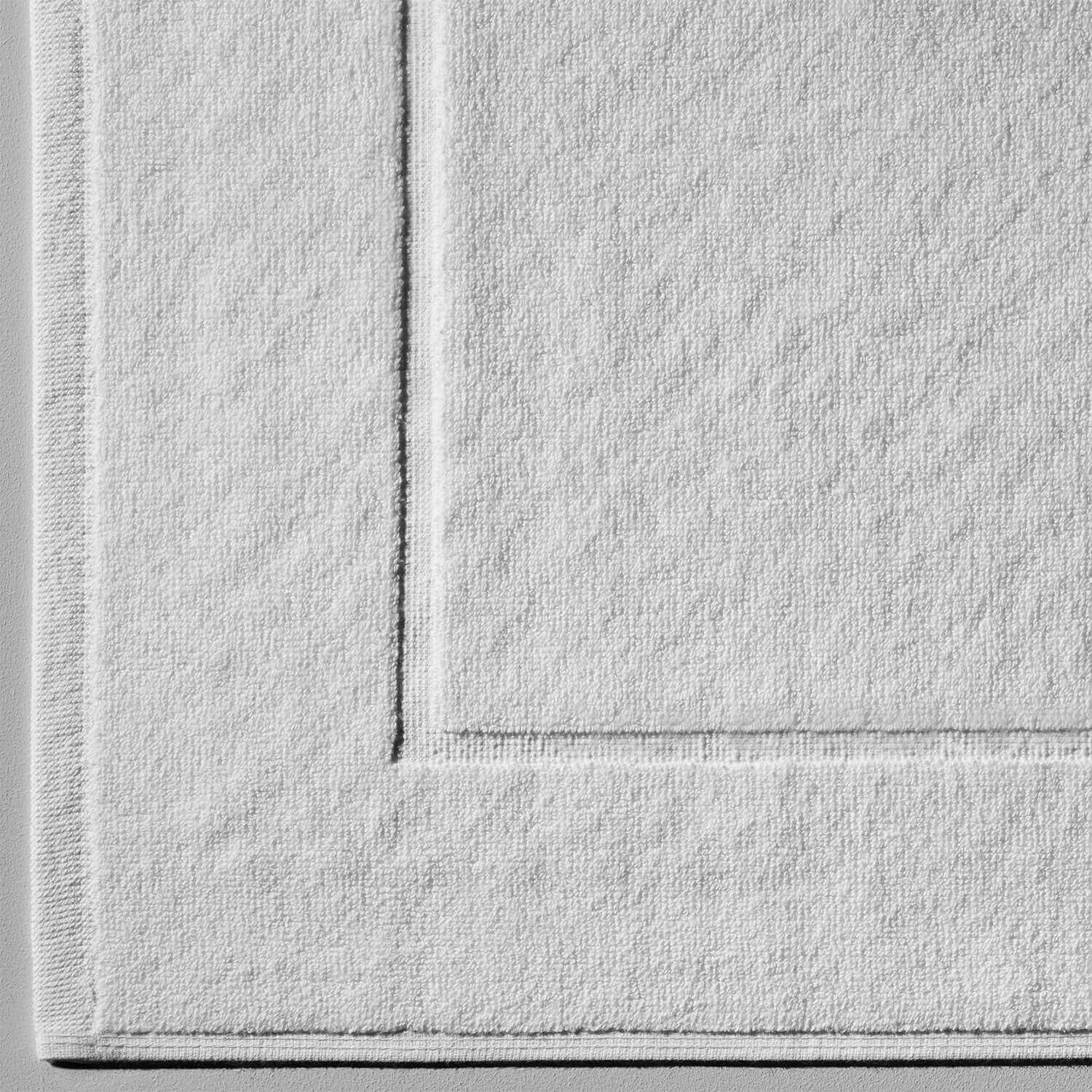Durable white terry mat featuring Slip-Less© technology, ideal for bathrooms and hotels.