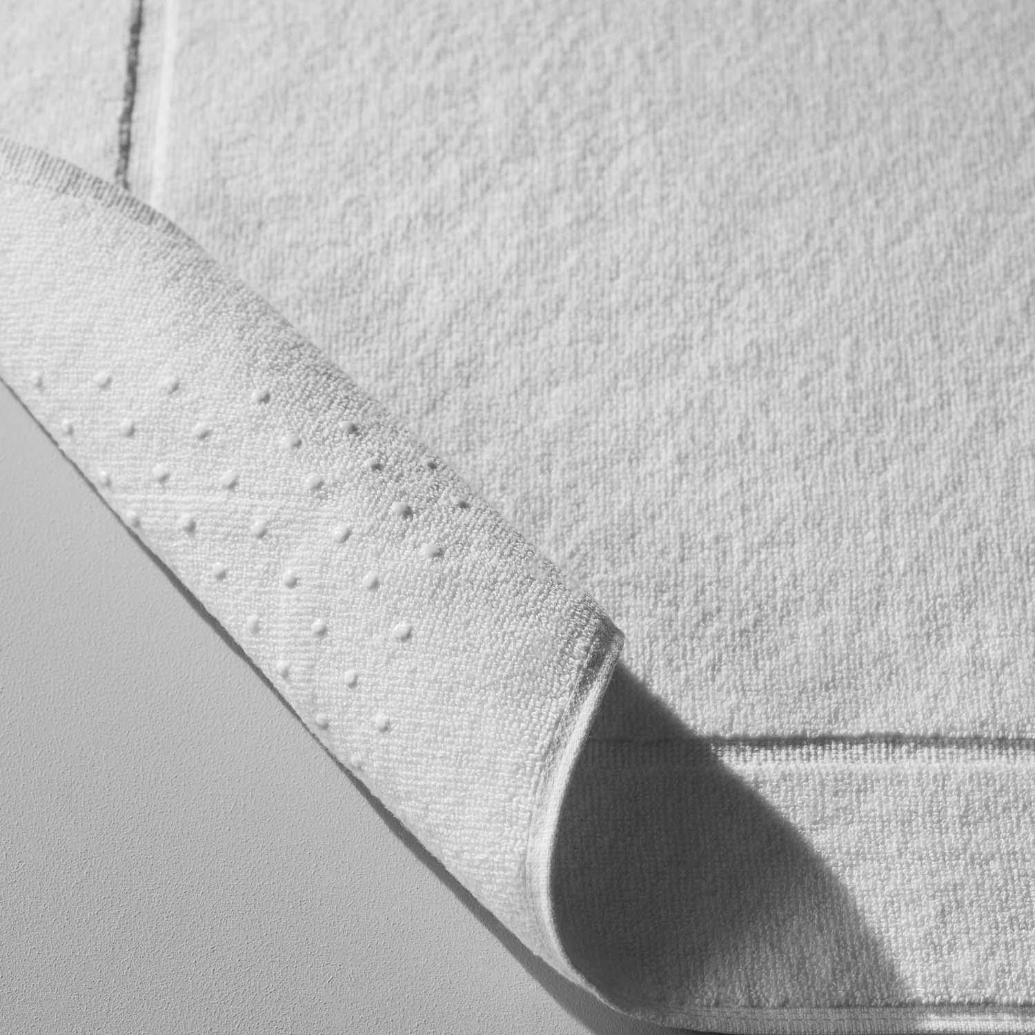 Close-up of a Terry Mat showcasing Slip-Less© technology, highlighting soft cotton and textured backing for safety.
