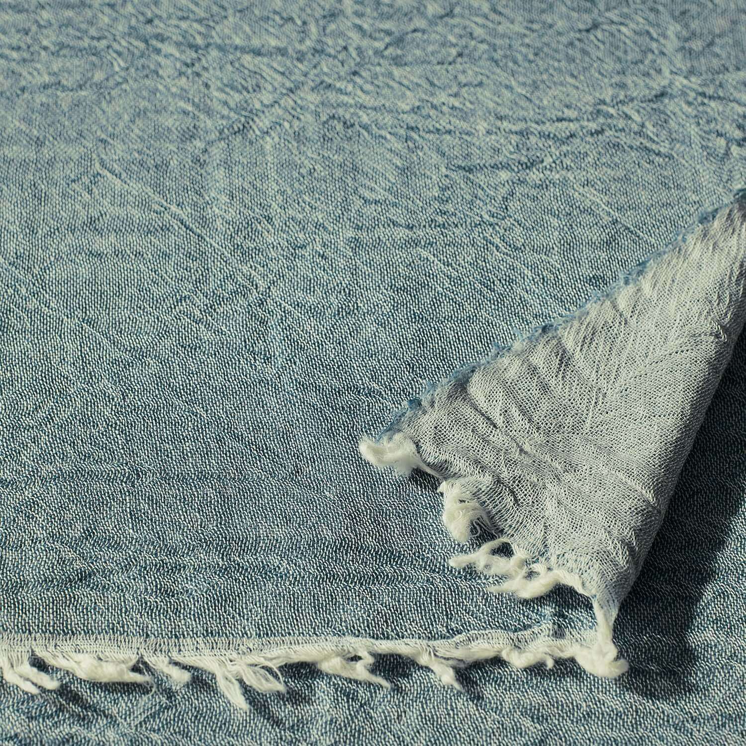 Soft blue Merino throw showcasing intricate two-tone weave and fringe detailing for elegant home decor.