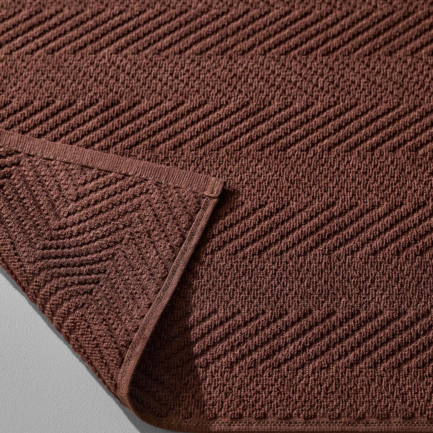 Brown treatment towel featuring a textured herringbone pattern, ideal for spas and colorfast for bleach use.