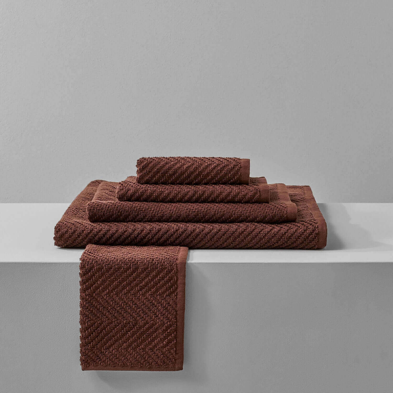 Stack of Treatment Towel Bruno Wholesale in rich brown, perfect for spa treatments and enhancing bath aesthetics.