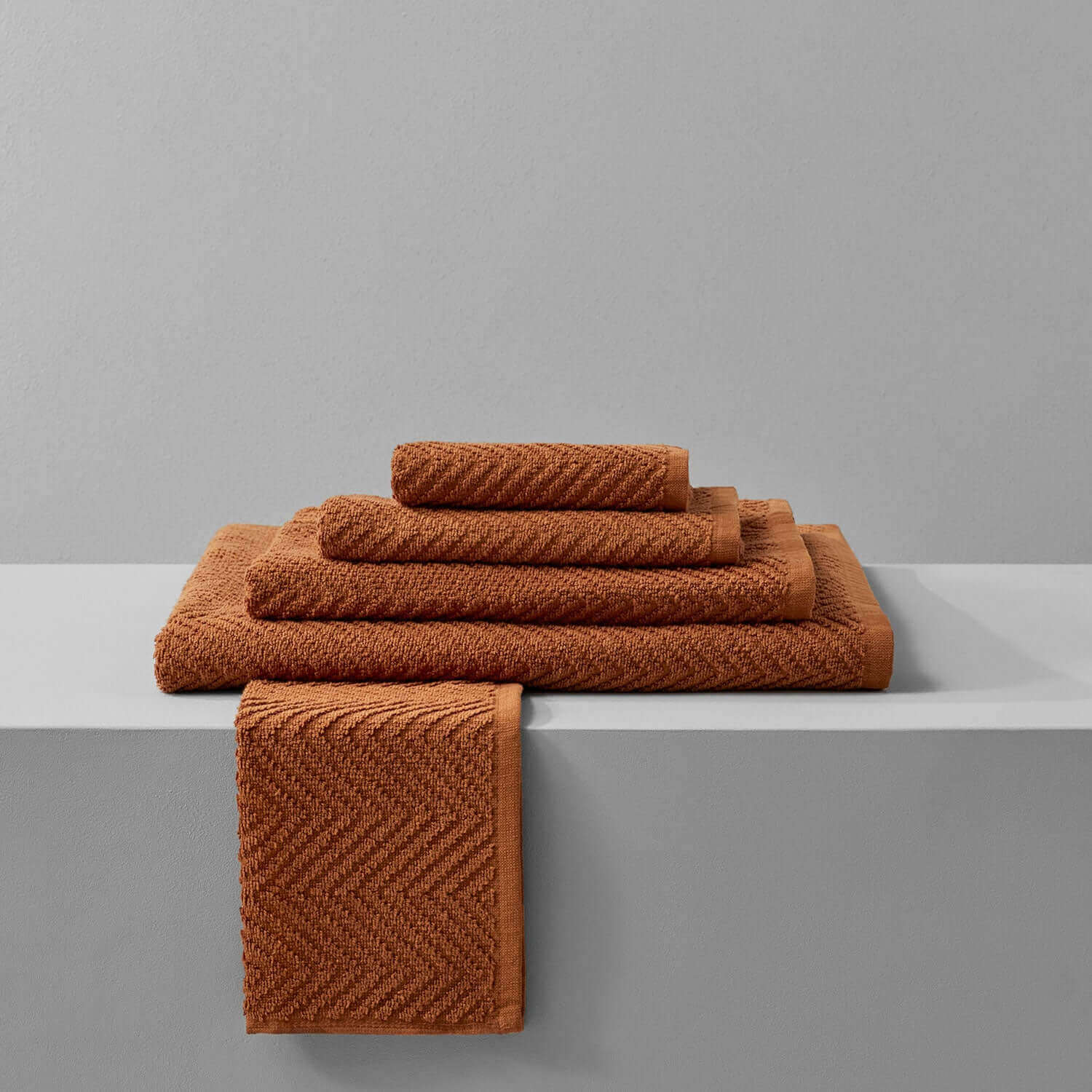 Clay treatment towels in warm terracotta hues, ideal for spa use and durable against bleach treatments.
