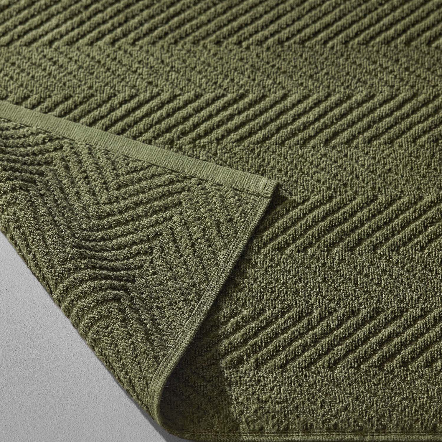 Treatment towel in olive green, featuring a textured herringbone pattern, ideal for spa and wellness use.