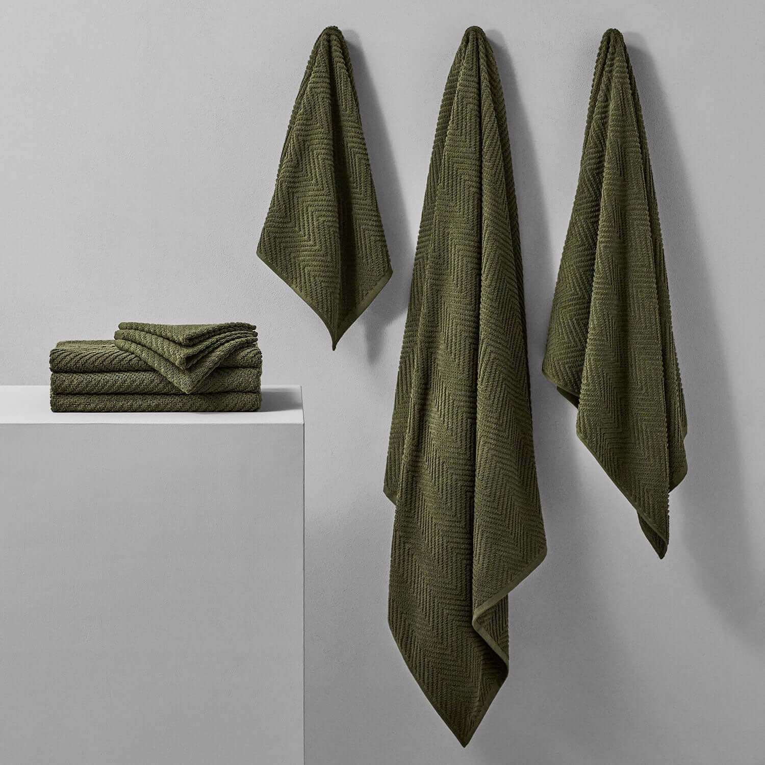 Olive treatment towels hanging and folded, inspired by nature for spa and bath use, resistant to bleach and color fading.