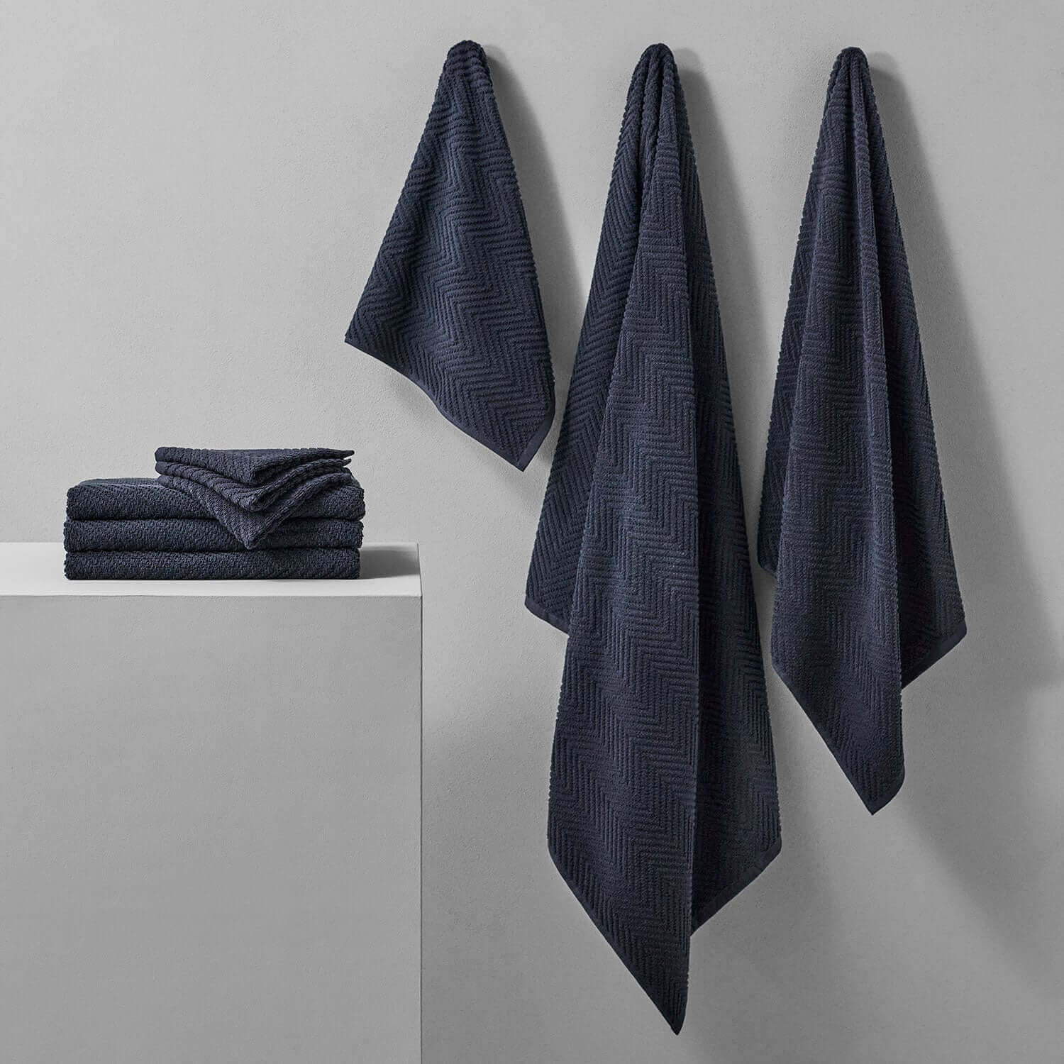 Slate treatment towels displayed on a wall and shelf, offering a stylish touch to bath or spa environments.