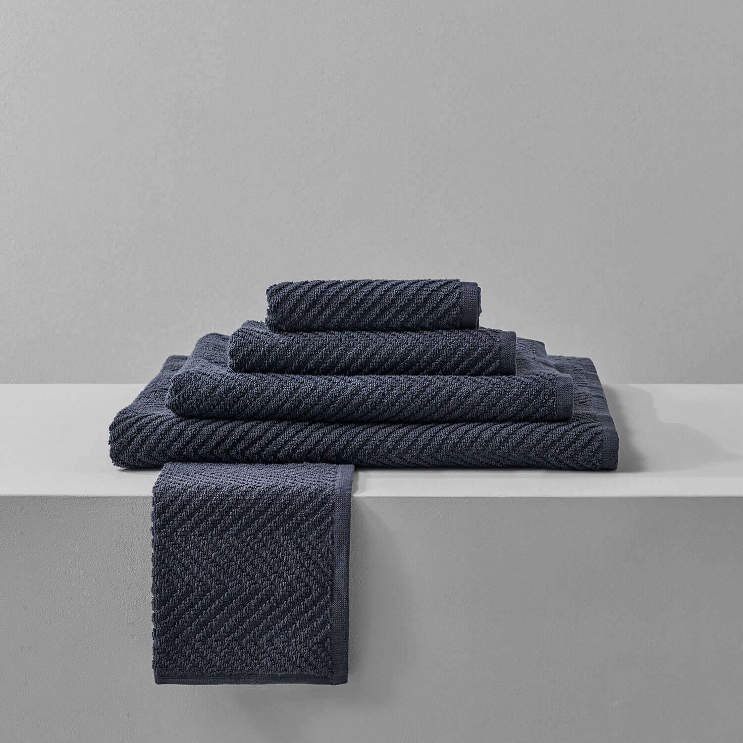 Slate treatment towels beautifully stacked on a shelf, perfect for luxurious spa experiences and clay treatments.