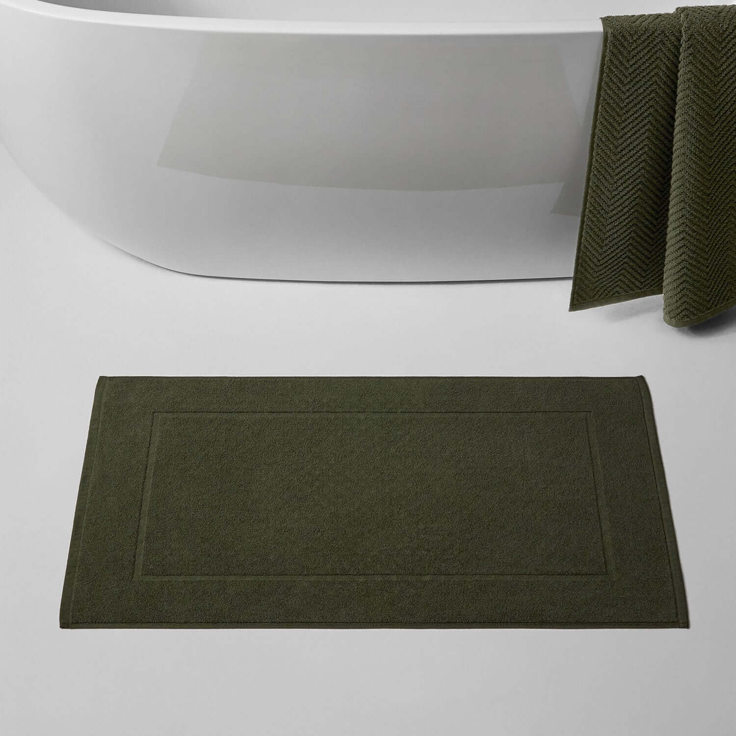 Olive treatment mat for spas, featuring innovative blotch-resistant color, positioned near a modern bathtub.