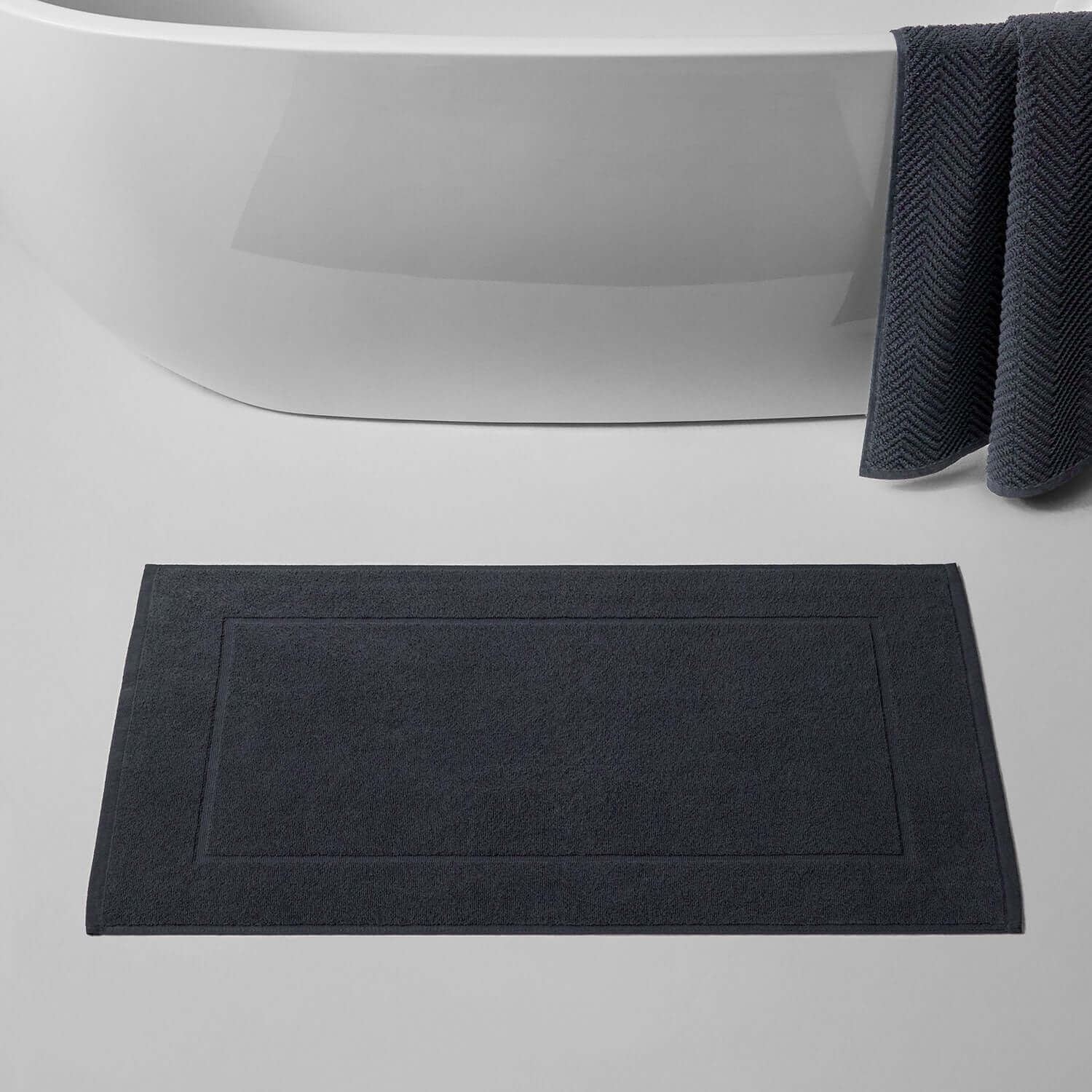 Slate treatment mat placed in a modern bathroom beside a freestanding tub, ideal for clay and mud treatments.