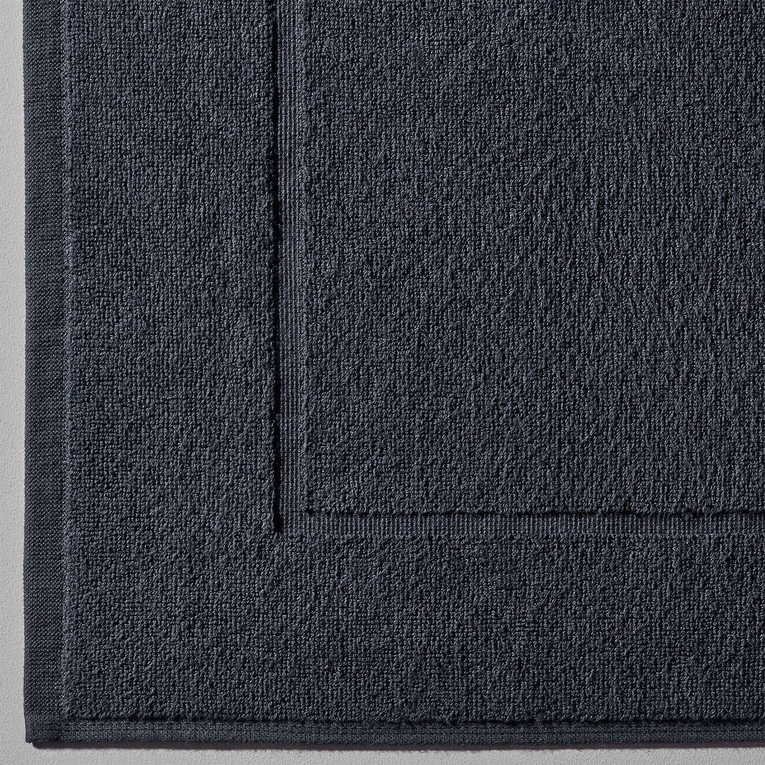 Close-up of dark slate treatment mat with textured surface, designed for spas and households for clay and mud applications.
