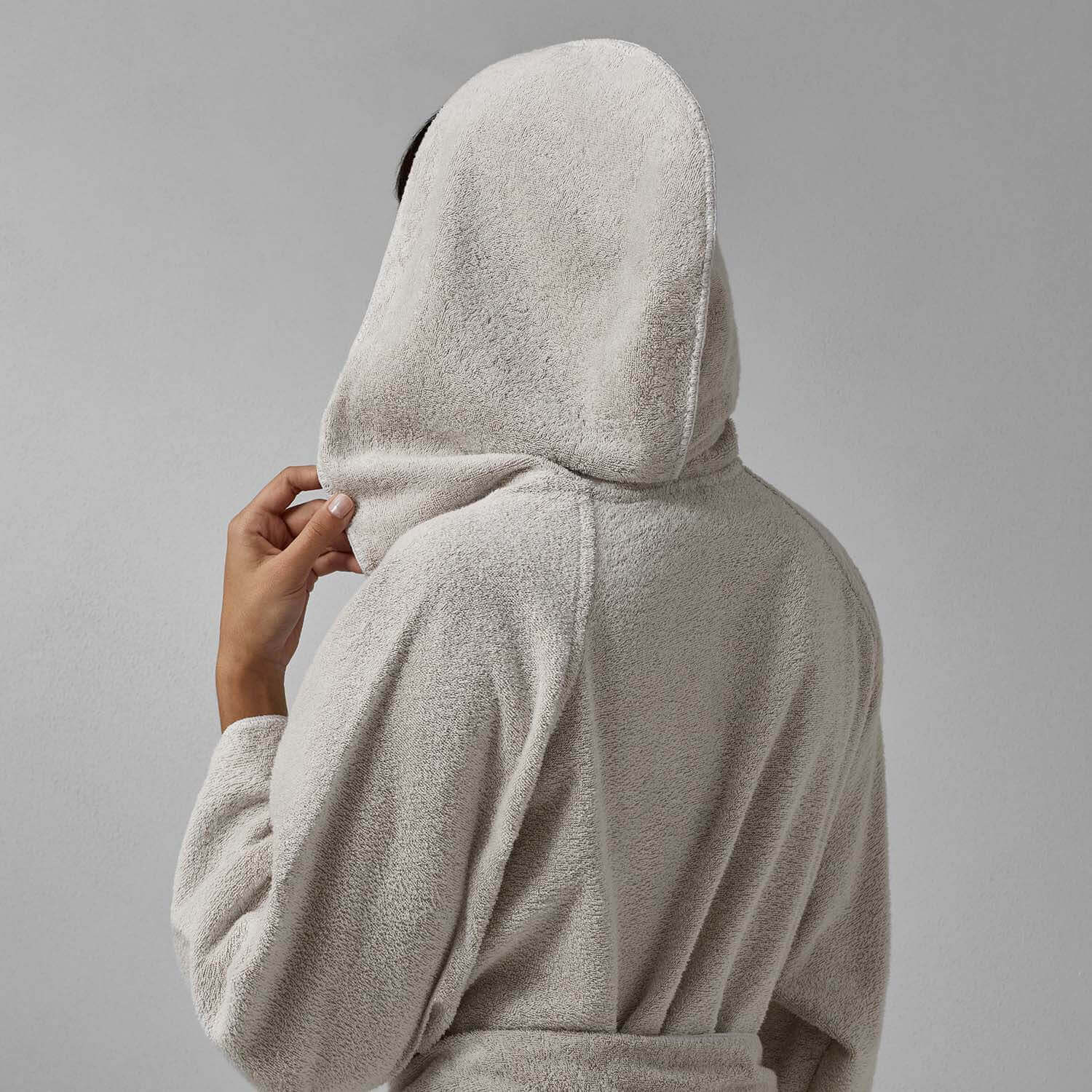 Back view of a person wearing a Tuxedo Hooded Sand robe in millennial grey with a stylish hood.