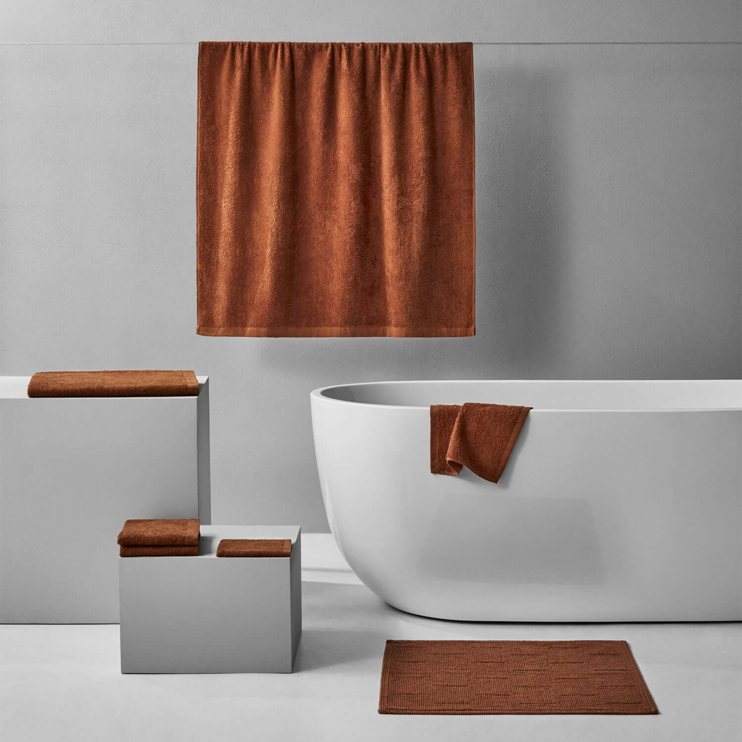 Wabi Sabi Bath Bundle in copper, highlighting minimalist towels and modern bathtub in a serene bathroom setting.