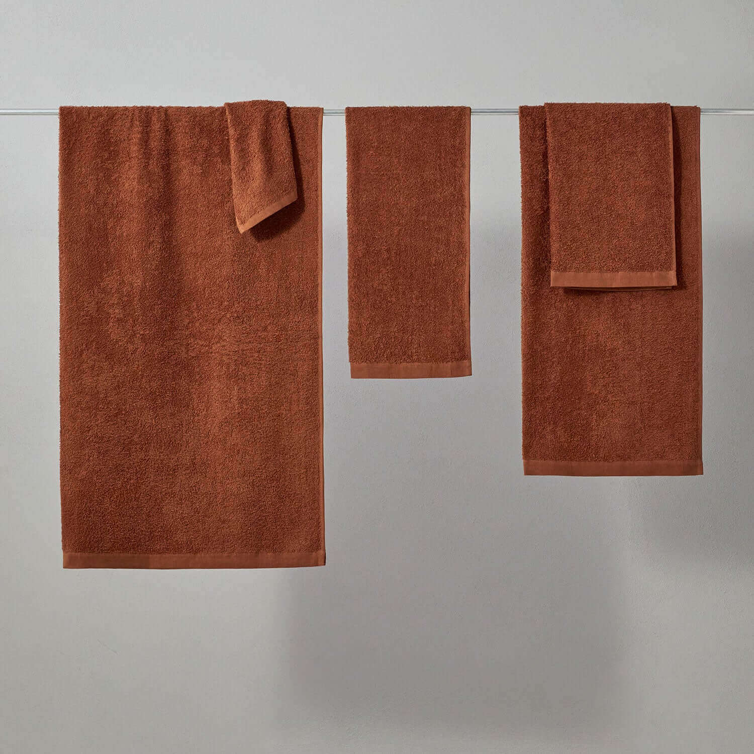 Wabi Sabi copper towels hanging on a rack, showcasing minimalist design and sustainable luxury.