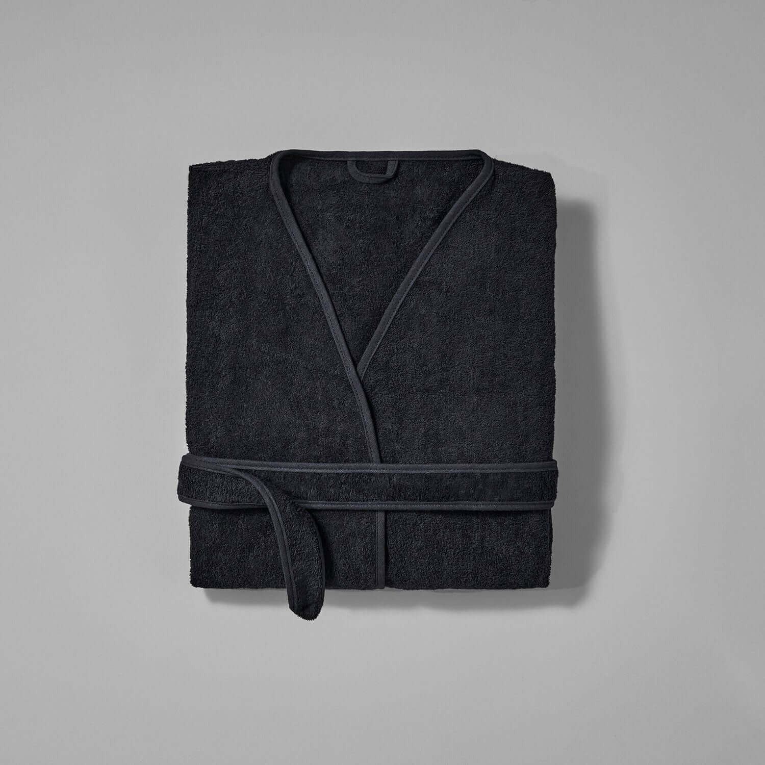 Wabi Sabi black robe featuring minimalist design and textured fabric, embodying luxury and sustainability.
