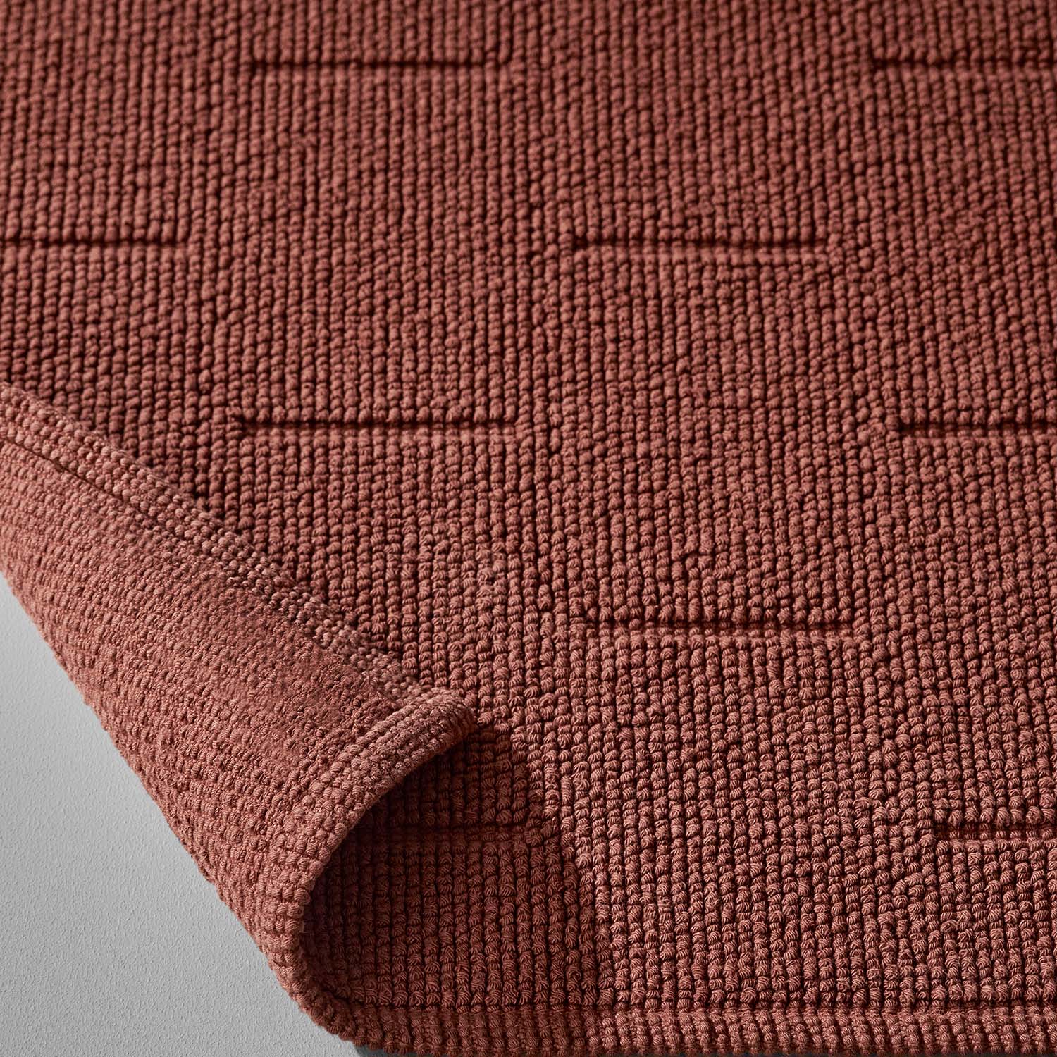 Wabi Sabi Tub Mat in copper hue, showcasing textured design inspired by minimalistic Japanese aesthetics.