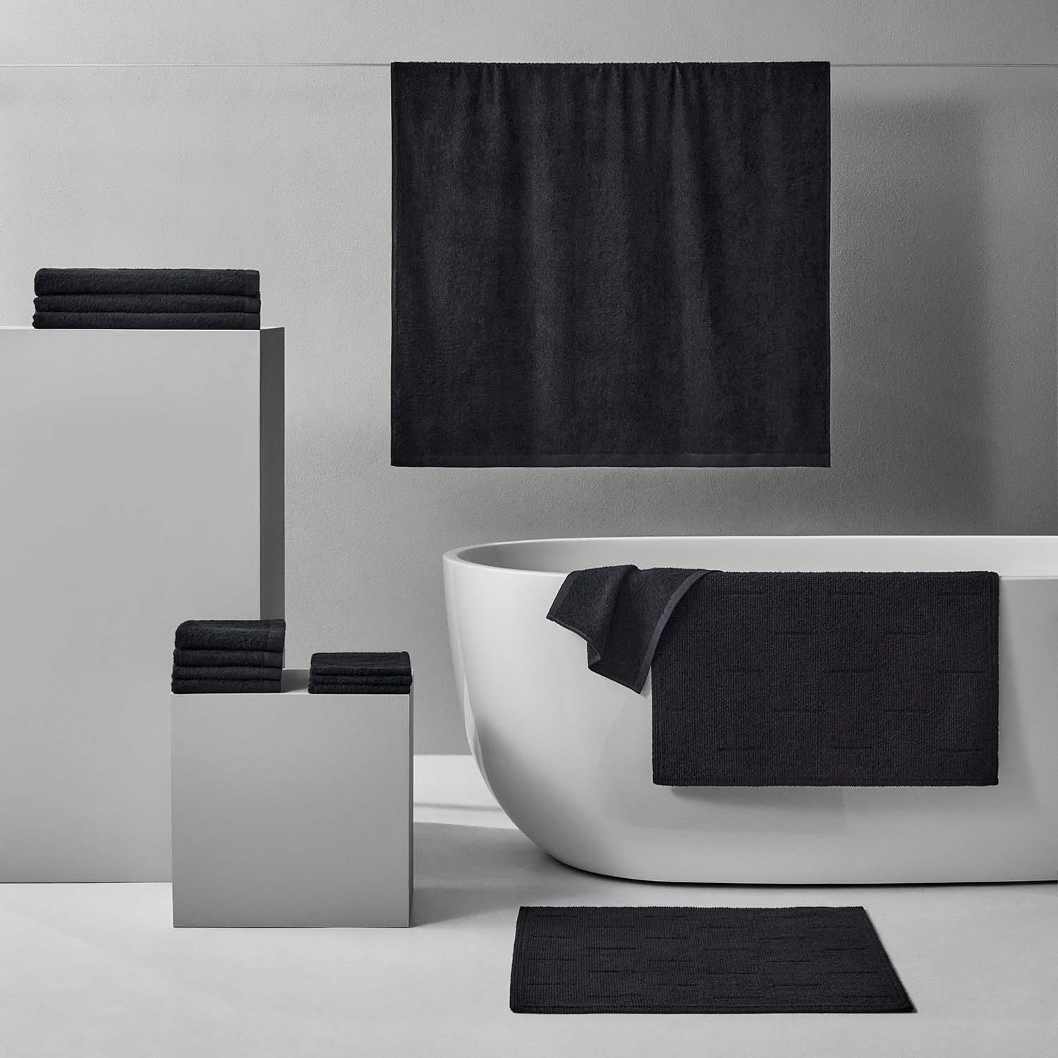 Wabi Sabi Bath Bundle in black, showcasing towels and mats with minimalist design for a luxurious bathroom aesthetic.