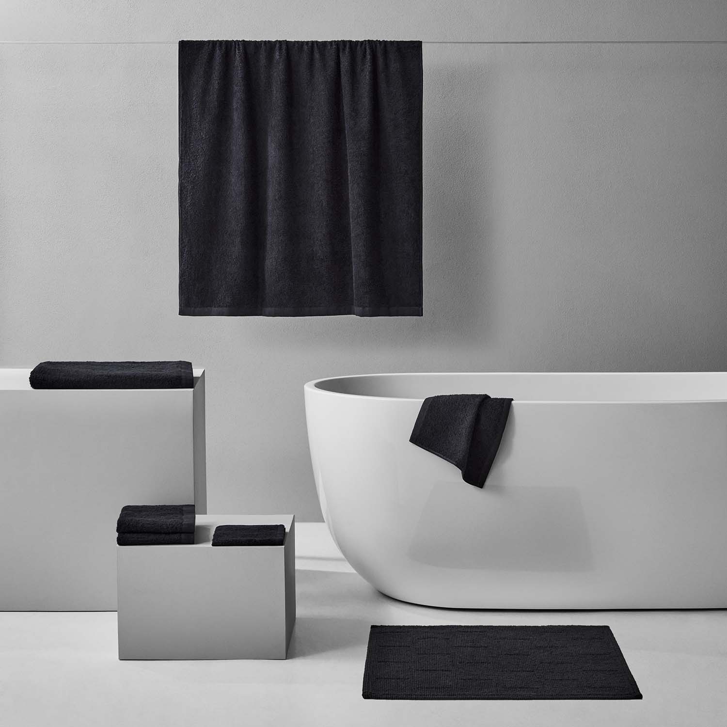 Wabi Sabi Bath Bundle in black featuring towels and mats, emphasizing minimalist design and sustainable luxury.