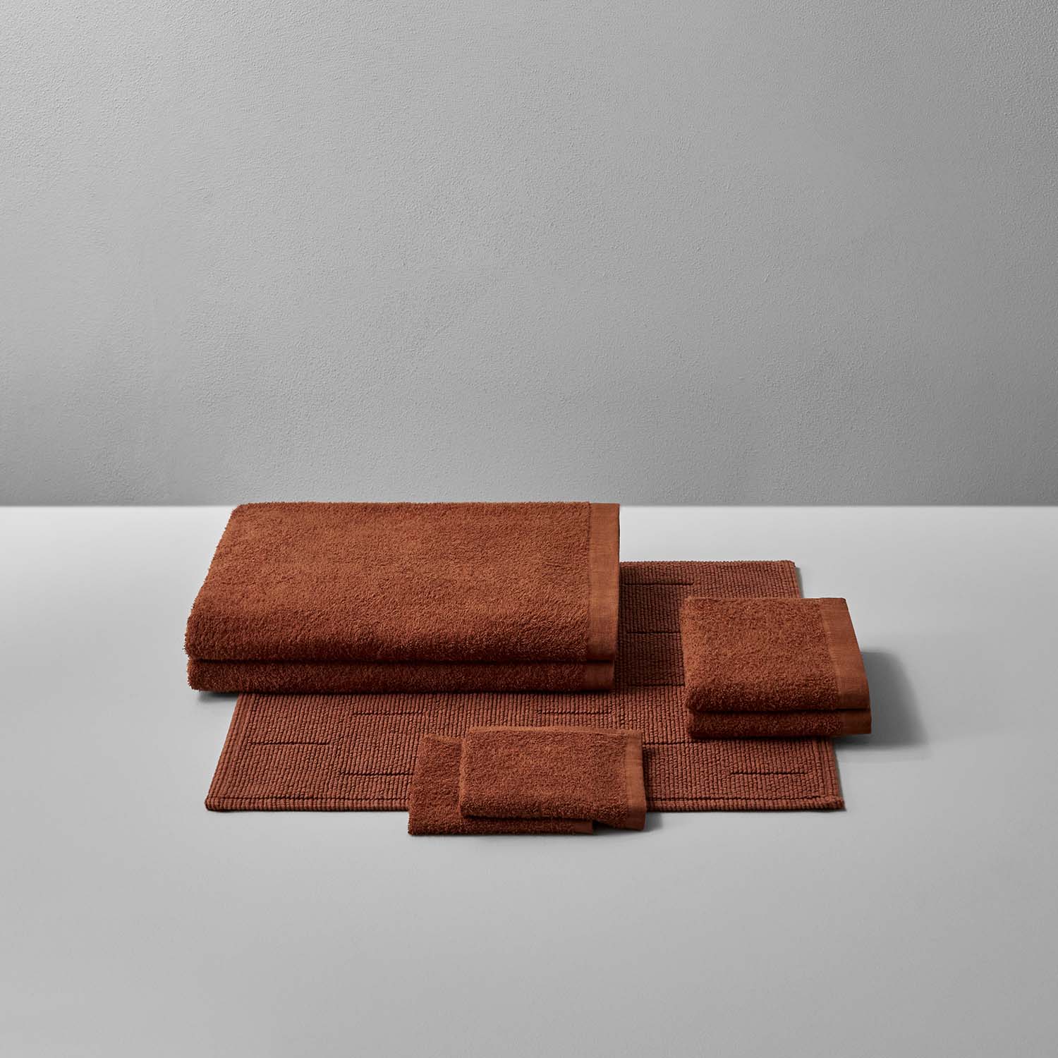 Wabi Sabi Bath Bundle in warm copper tones, featuring plush towels and mats for a serene bath experience.