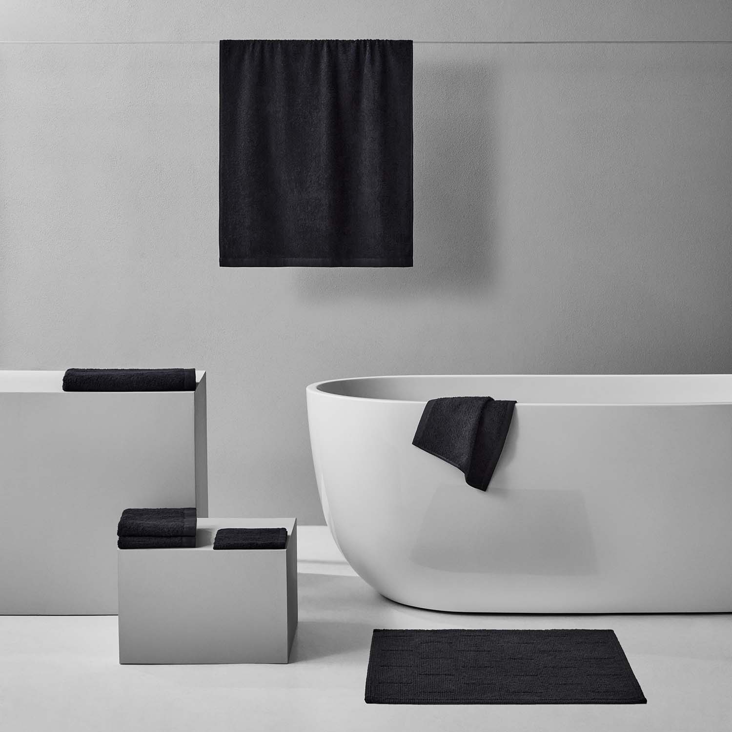 Wabi Sabi Bath Bundle in black, showcasing minimalist design with towels and a sleek bathtub for a tranquil bathroom ambiance.