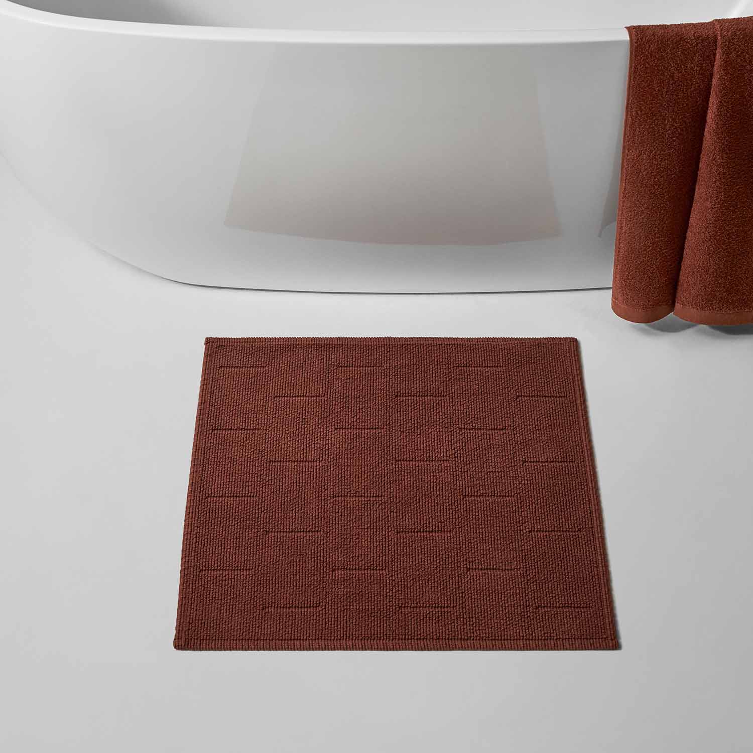 Wabi Sabi copper bath mat in textured design, inspired by minimalist Japanese aesthetics, on a bathroom floor.