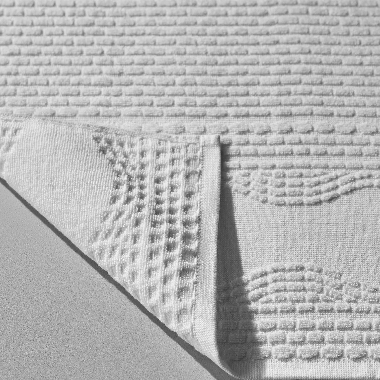 Pure cotton wave-patterned towel showcasing absorbent texture, perfect for beachside or poolside relaxation.