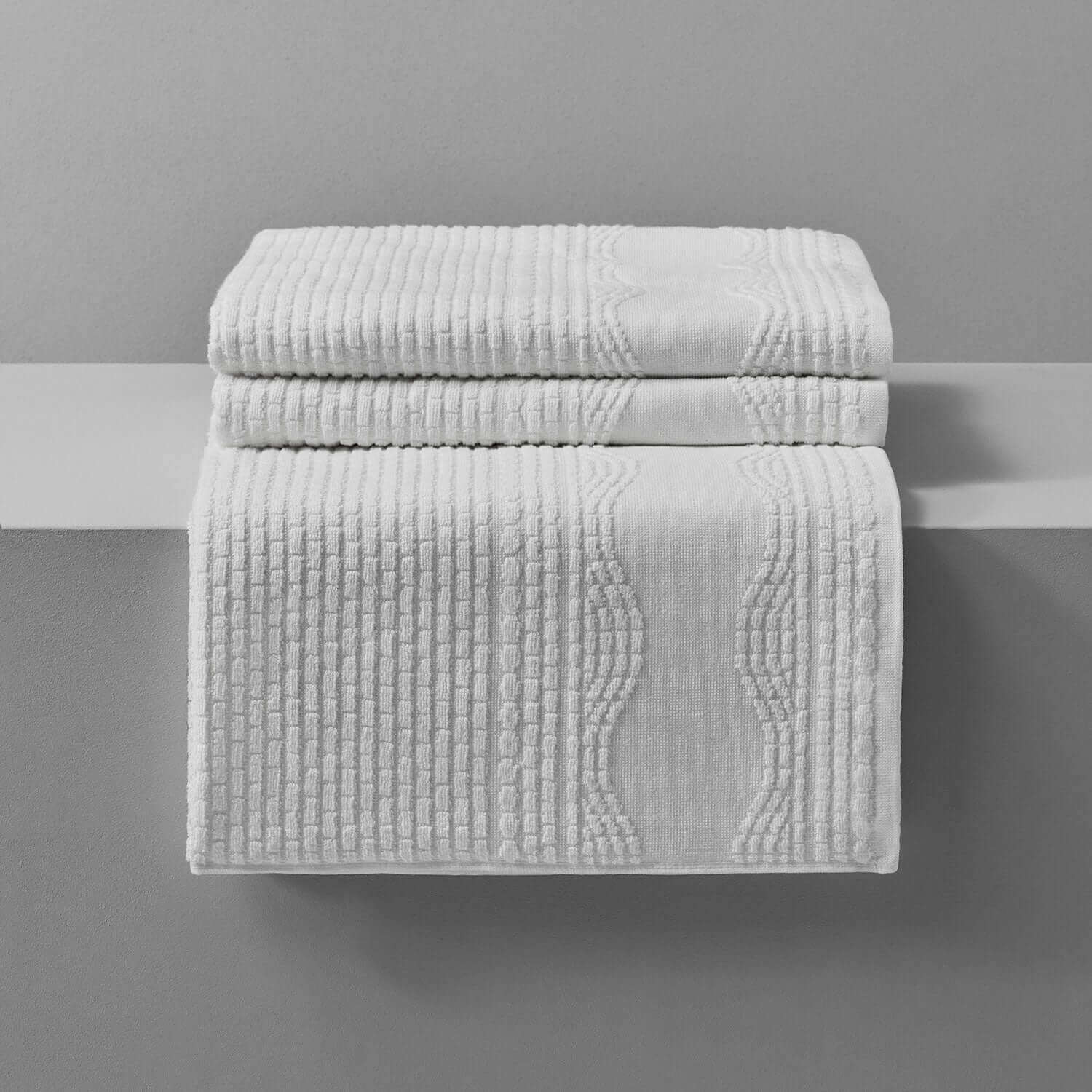 Luxurious white Wave Towel stack, perfect for beach and pool use, showcasing a stylish wave pattern on pure cotton.