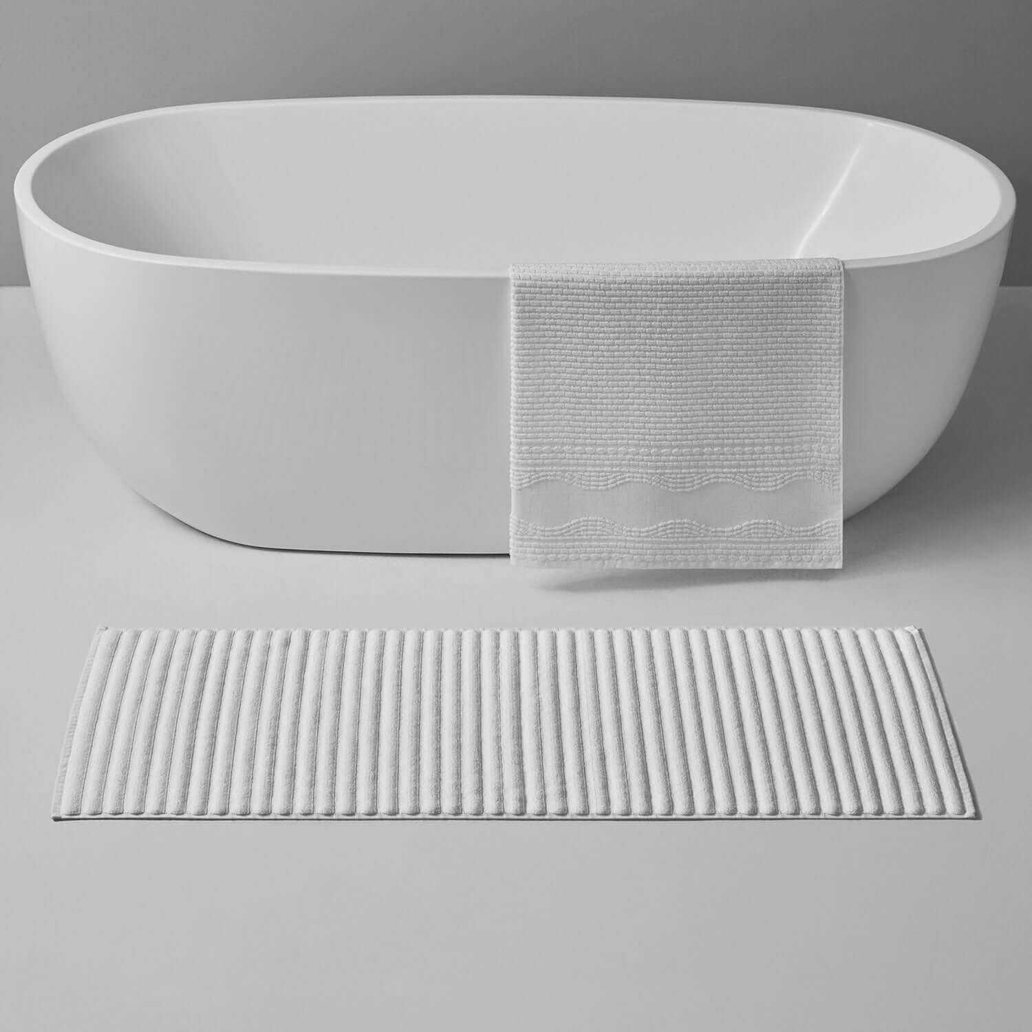 Luxurious Wave Mat in front of a modern bathtub, offering soft, safe footing for daily rituals.