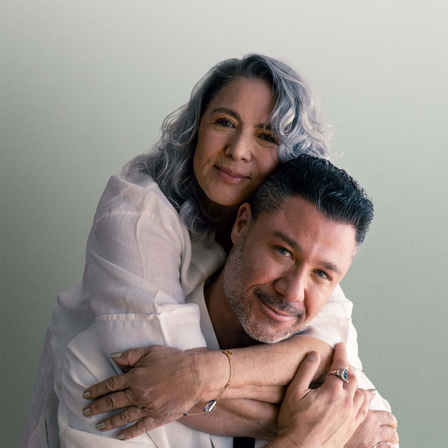 A joyful couple embracing, showcasing love and intimacy in a softly lit setting, perfect for family and relationship themes.