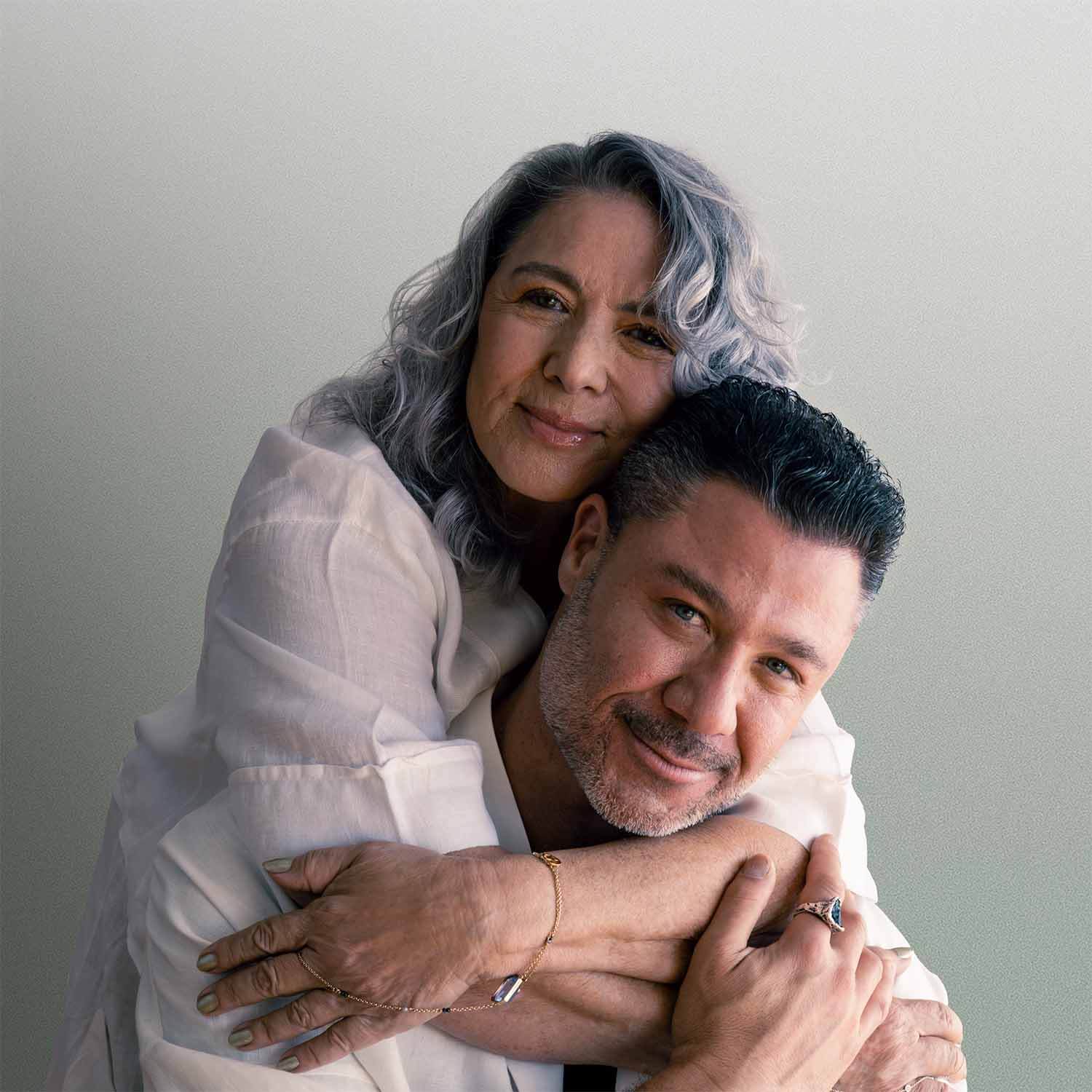 A couple sharing a warm embrace, showcasing love and connection, with soft light background.