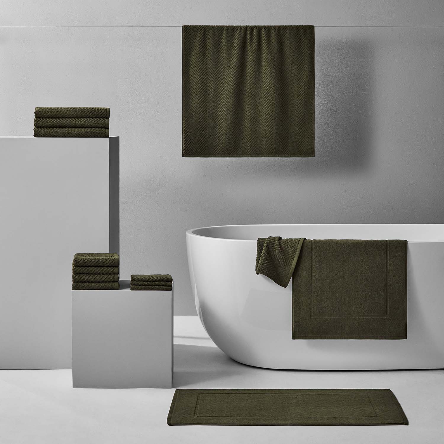 Treatment Bath Bundle in olive tones, featuring soft towels and mat, enhancing relaxation and comfort.