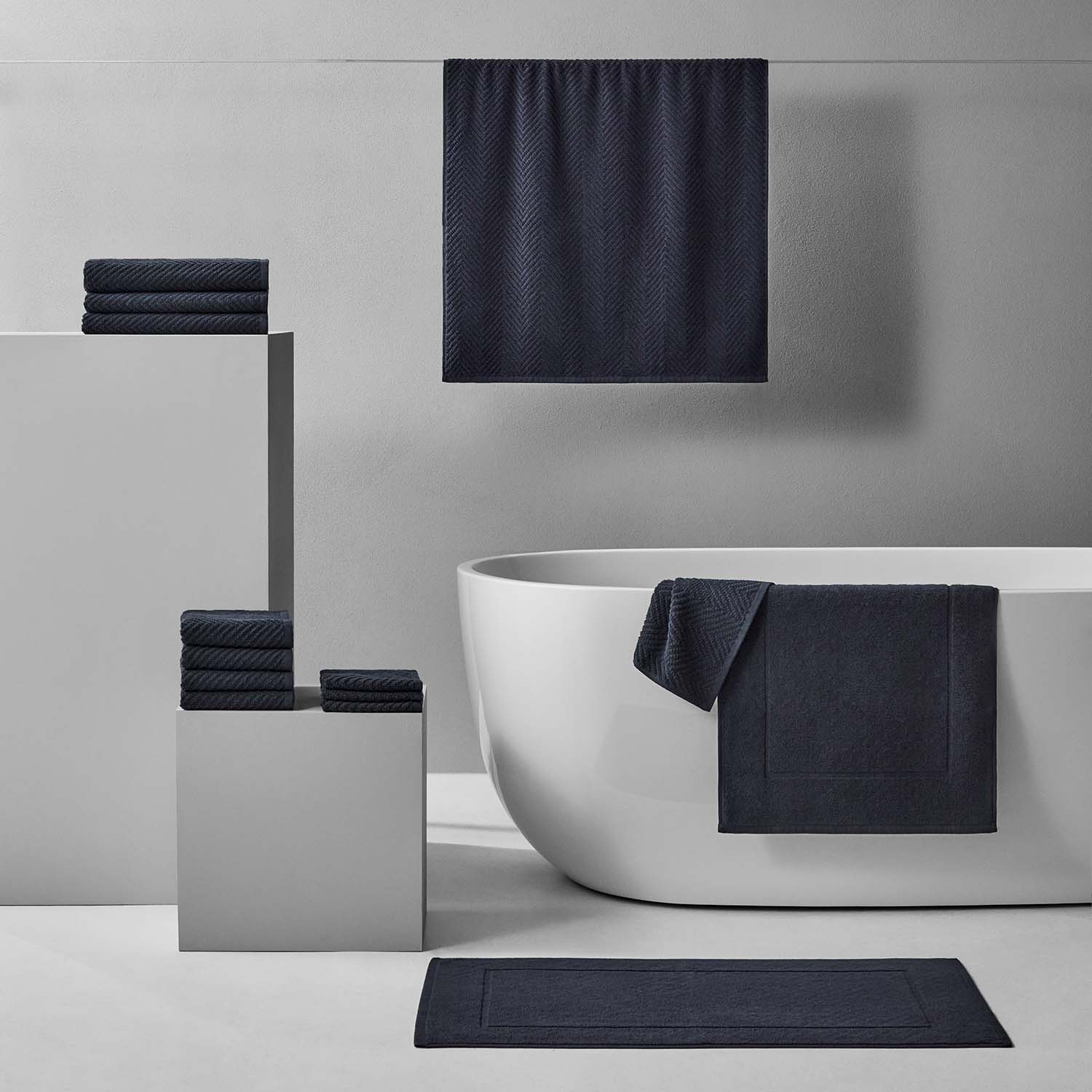 Slate Treatment Bath Bundle featuring dark towels and bath mats in a modern bathroom setting.