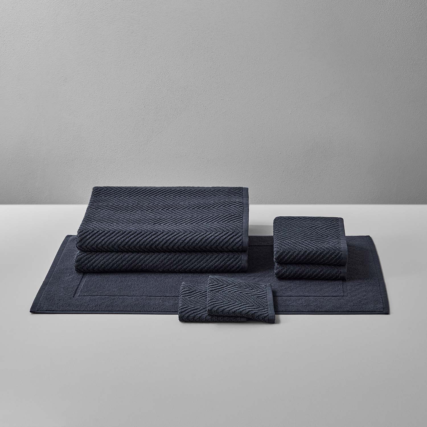 Treatment Bath Bundle Slate featuring soft, durable towels and mats in warm, earthen tones for comfort and relaxation.
