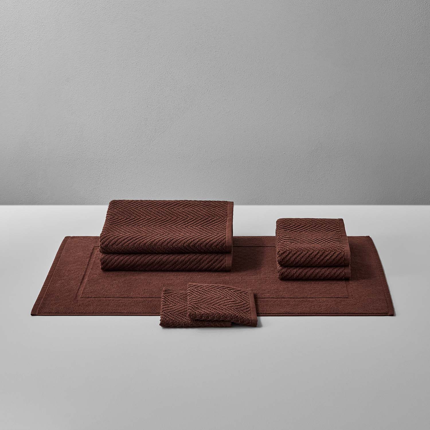 Treatment Bath Bundle Bruno includes soft brown towels and mats, featuring elegant herringbone patterns for relaxation.