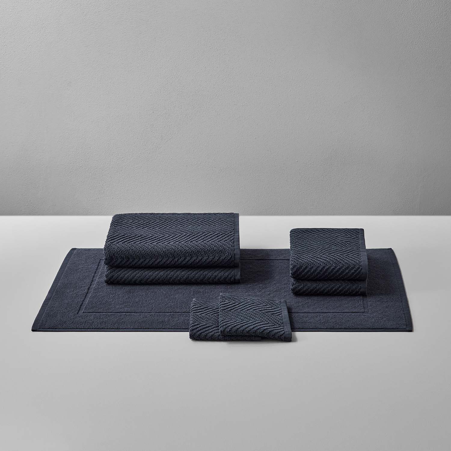 Treatment Bath Bundle Slate featuring soft textured towels and mats in warm earthen tones for relaxation and comfort.