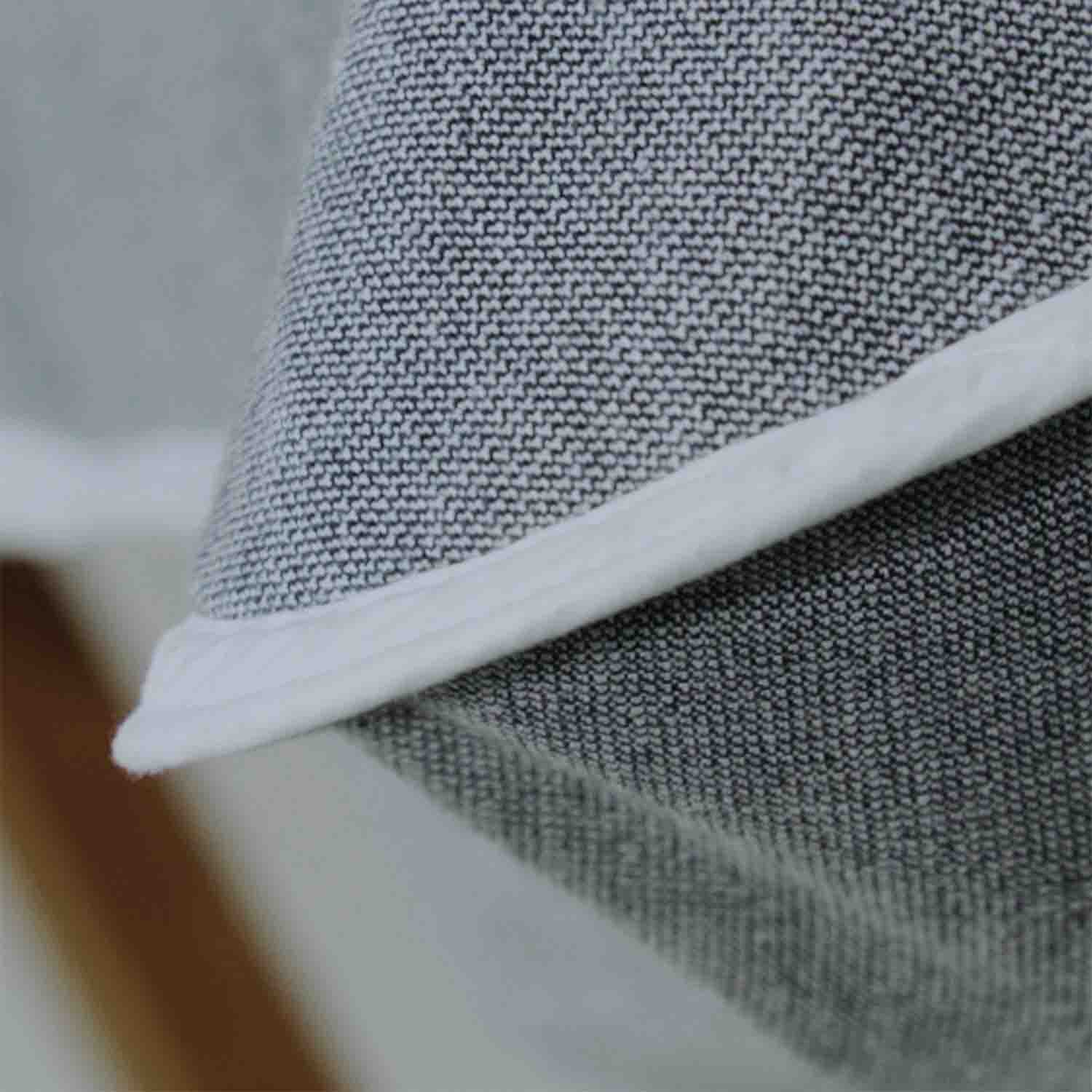 Close-up of the gray fabric of a SOL Lounge Chair Cover, showcasing its secure-fit top sleeve and elegant weave.